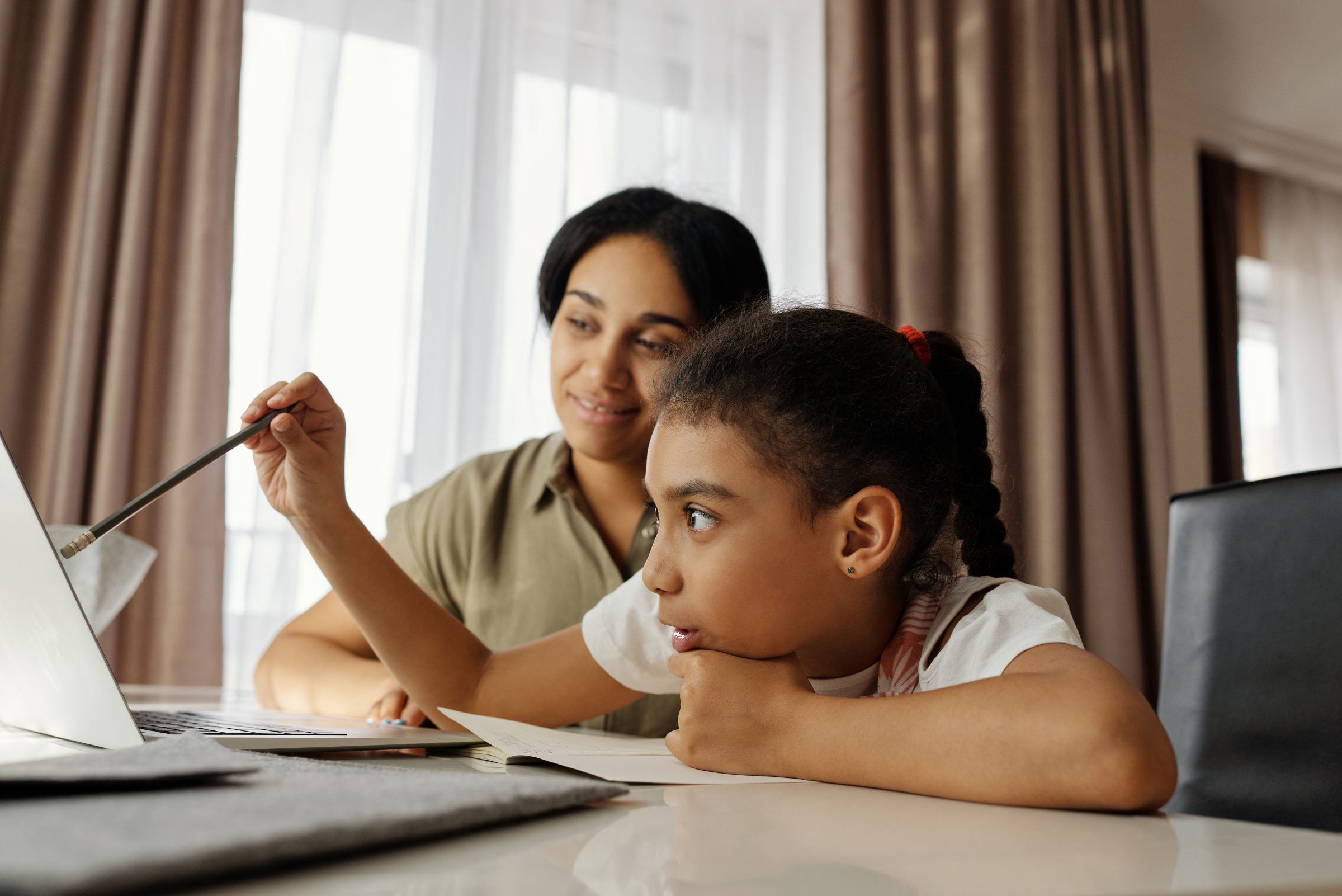 Mãe multicultural ajudando a filha a estudar educar doméstico homeschooling