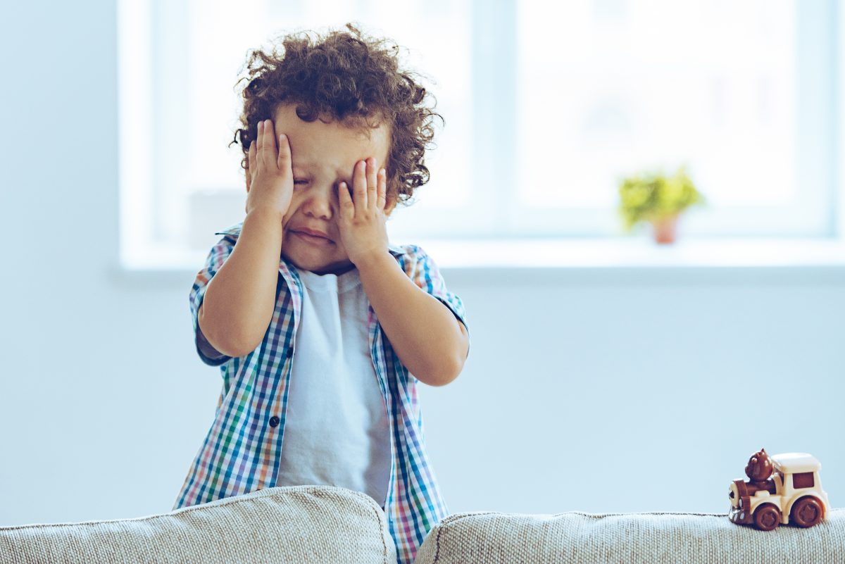 ah nao bebezinho africano chorando e esfregando os olhos enquanto esta de pe no sofa de casa 3