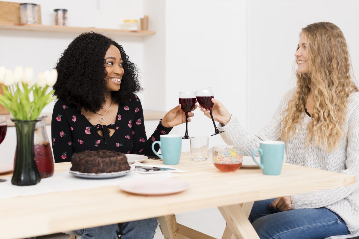 A adaptação cultural e o construir de novas amizades 4 amigos torcendo com um copo de vinho