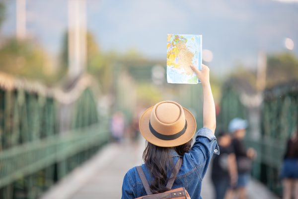 femininos turistas na mao tem um mapa de viagem feliz